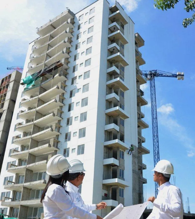 Ingenieros de Proyecting AM revisando planos frente a una torre