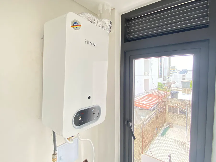 Instalación de calentador a gas junto a ventana